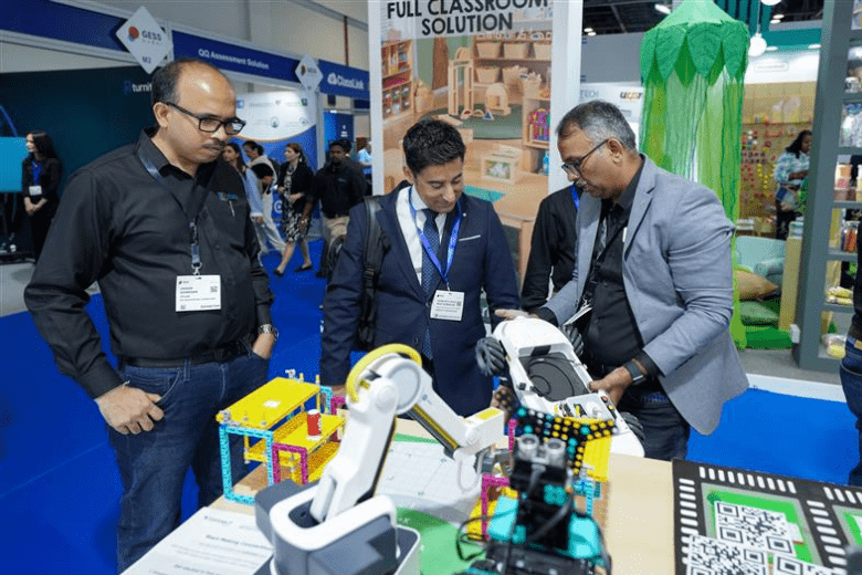 Education professionals examine interactive robotics equipment during a demo at an educational technology exhibition in Dubai