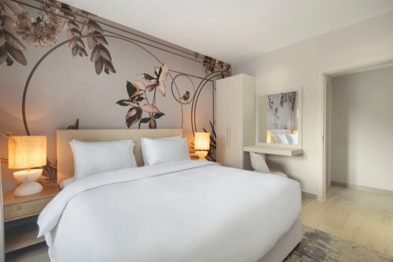 Elegant king bedroom at Rixos Obhur Jeddah with floral mural and soft lighting