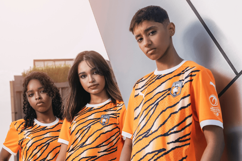 Eastern Flames FC players modelling the 2025/26 home kit with tiger-stripe design by PUMA